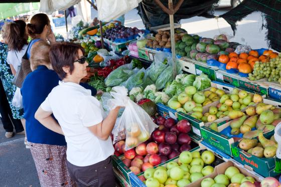 Kvinne studerer frukt og grønt på marked
