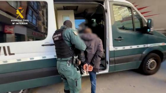 Arrestant geleides inn i politibil.