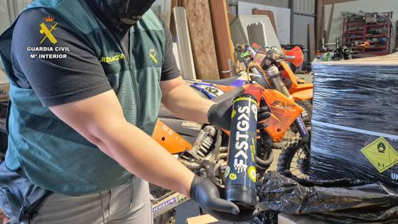 Politibetjent holder en beholder med lystgass.