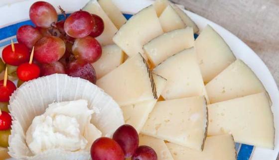 Fat med ost og druer pyntelig arrangert.