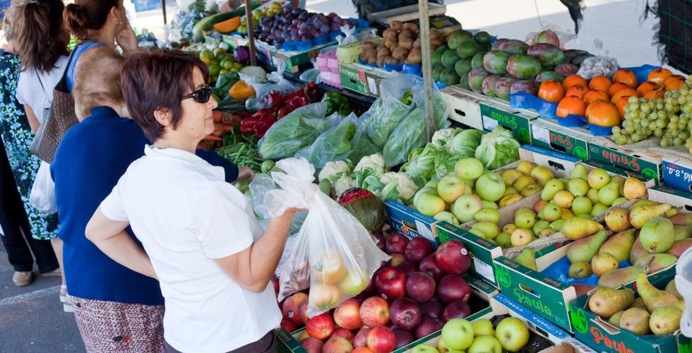 Kvinne studerer frukt og grønt på marked