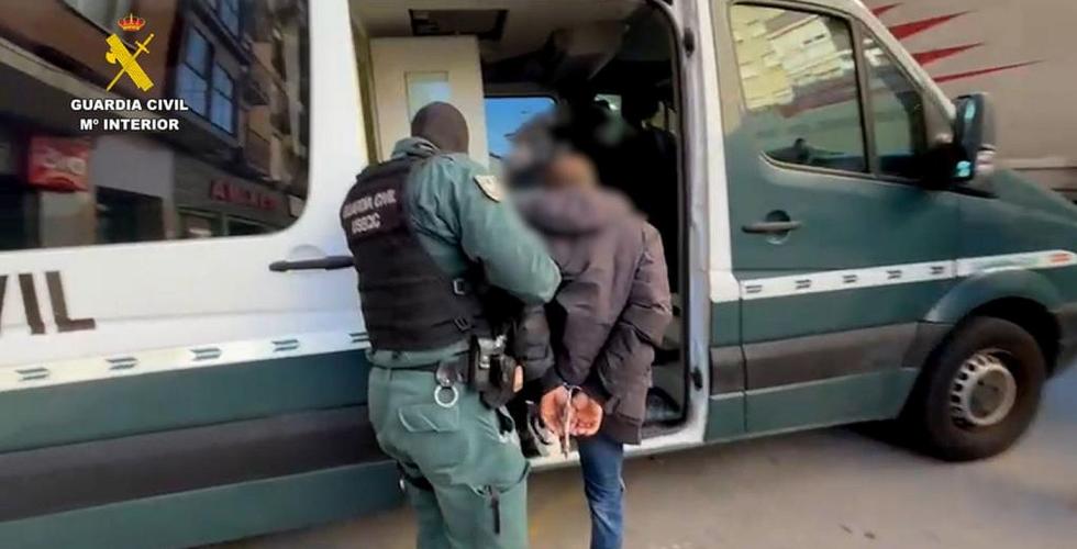 Arrestant geleides inn i politibil.