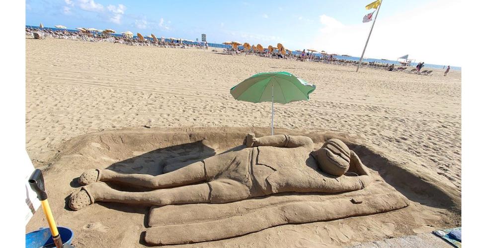 Sandskulptur under parsaoll på strand.