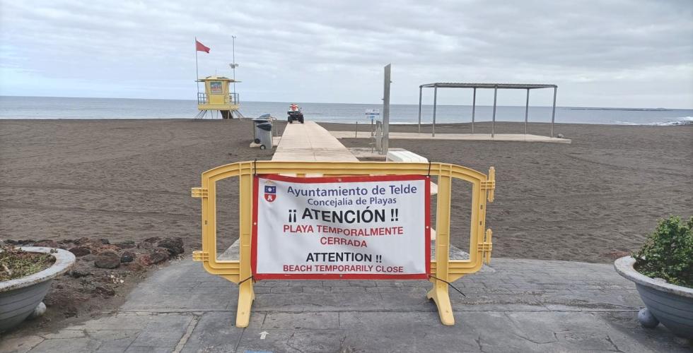 Skilt foran strand med teksten midlertidig stengt på spansk.