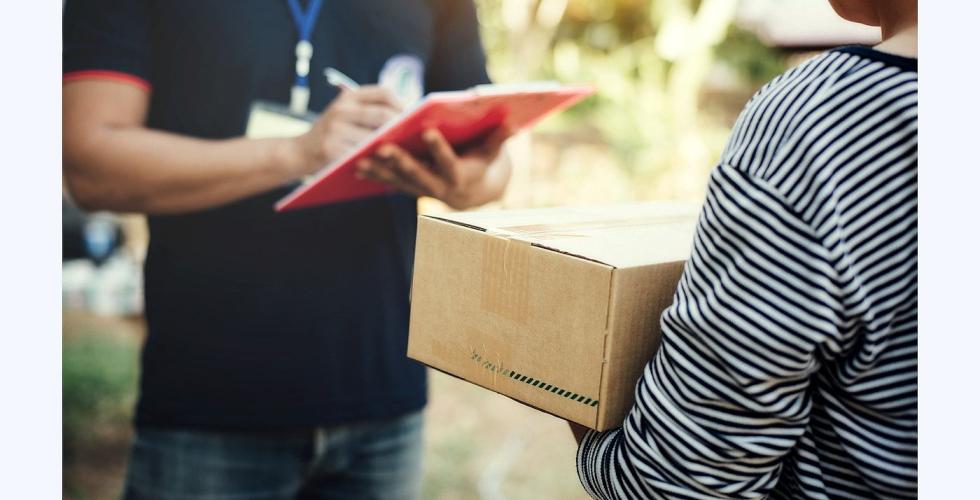 Person mottar en pakke fra postmann.