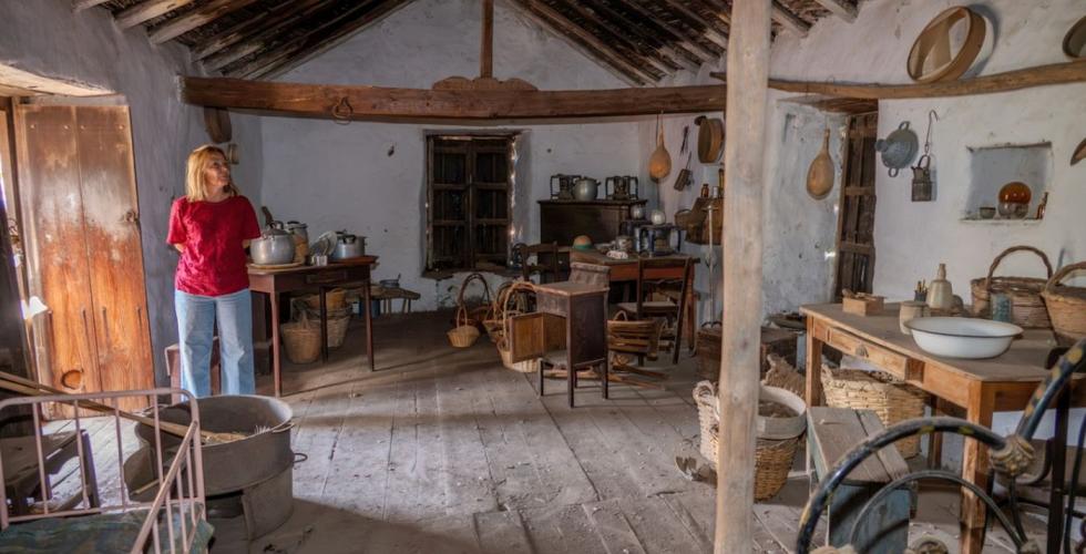 En kvinne står inne i et gammelt hus