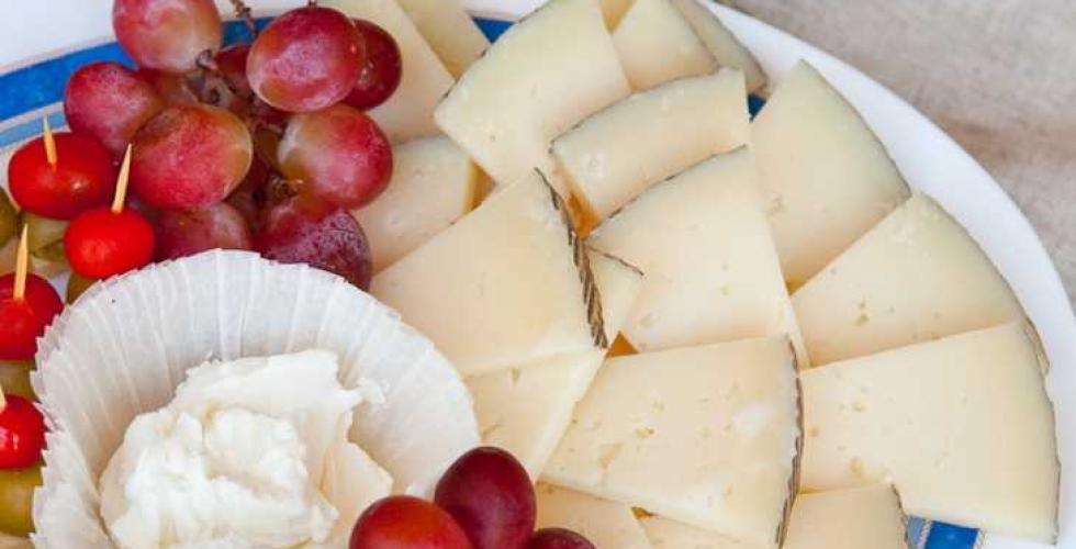 Fat med ost og druer pyntelig arrangert.