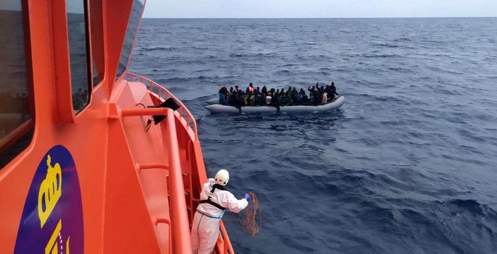 Båtflyktninger møter redningsbåt på åpent hav.