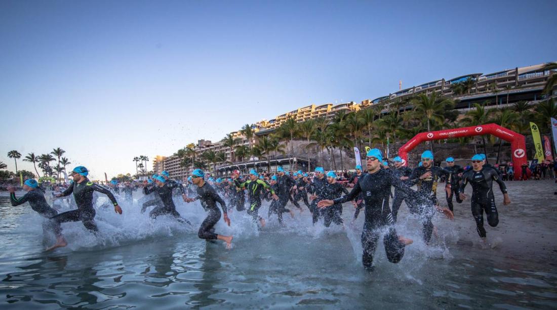 Konkurrenter i fullt sprang ut i vannet fra stranden. 